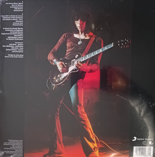 Person playing guitar on a dark background with red lighting