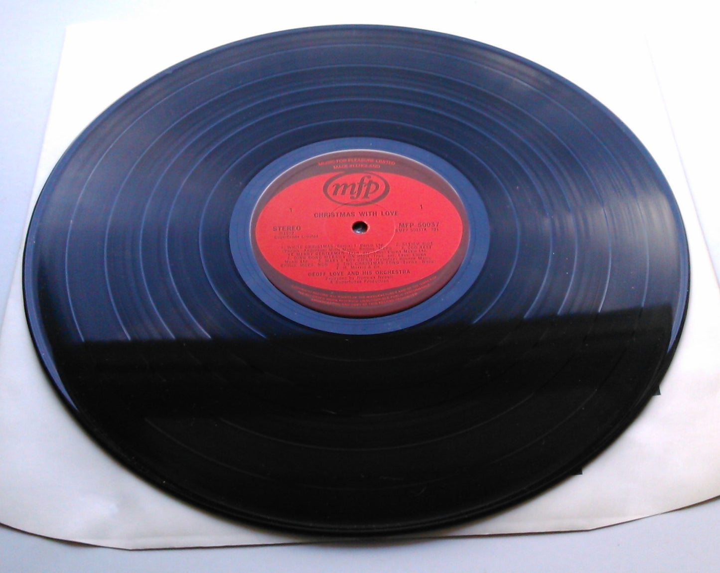 Vinyl record with a red label on a white background