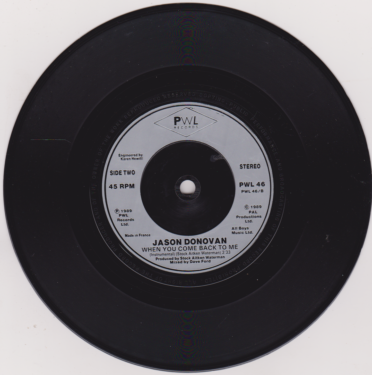 Vinyl record with PWL Records label on a white background
