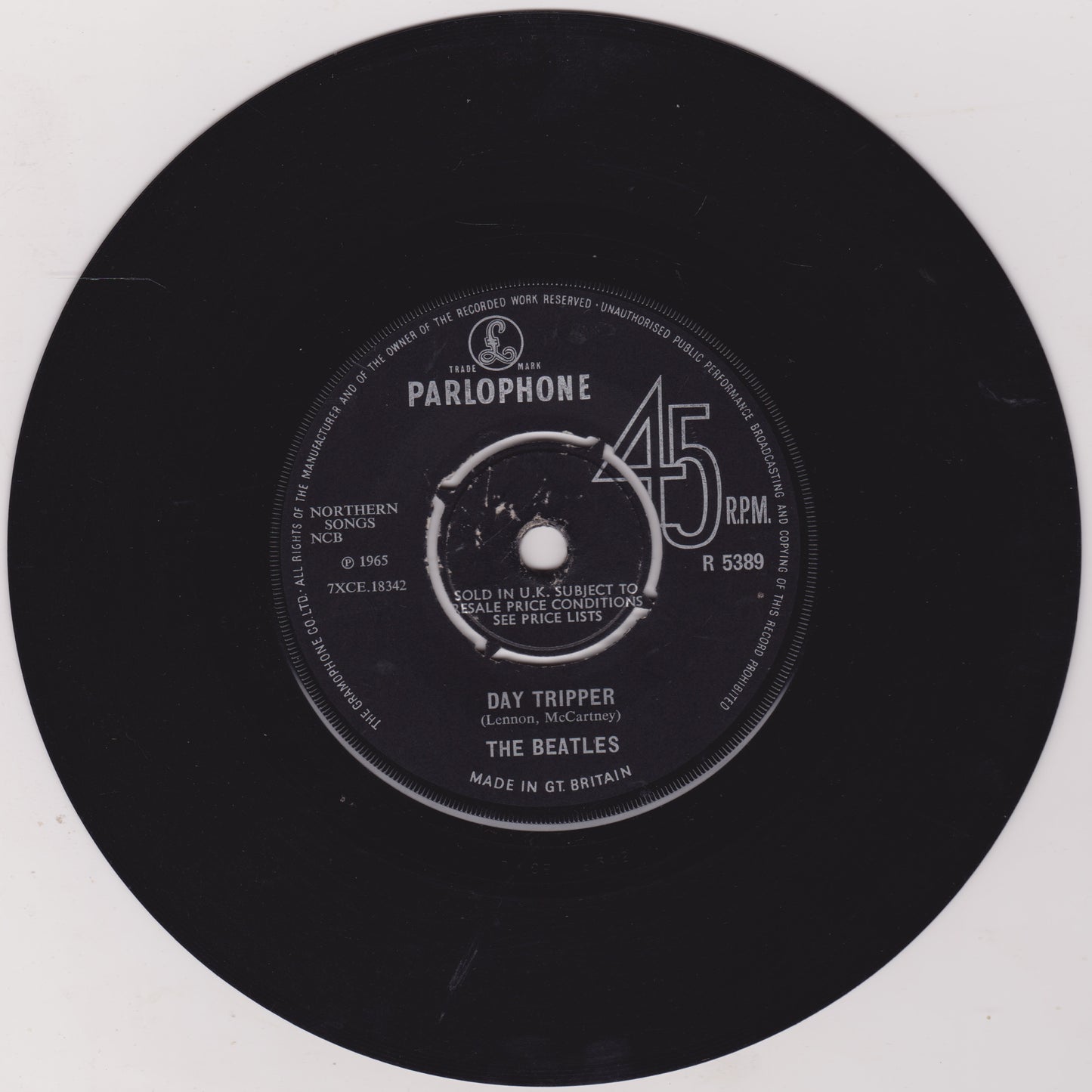 Black vinyl record with Parlophone label and 'Day Tripper' by The Beatles on a white background