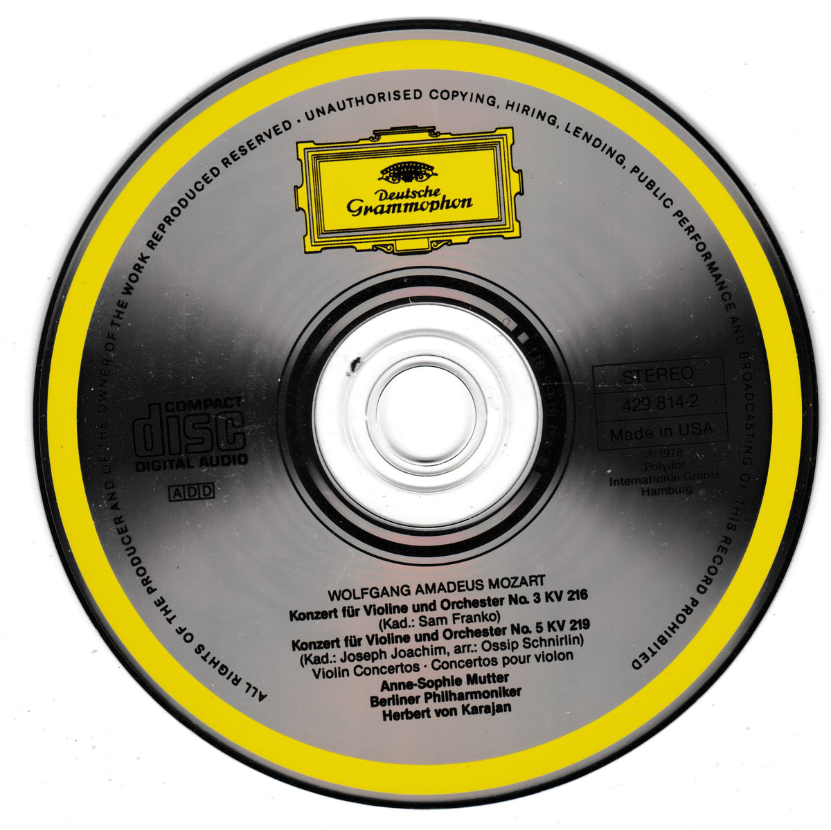 A compact disc with a black and yellow label featuring the Deutsche Grammophon logo and Mozart's violin concertos, photographed on a white background.
