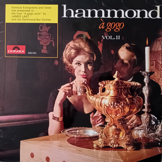 Album cover for 'hammond a gogo Vol. II' featuring a woman and man at a table with a large decorative urn.