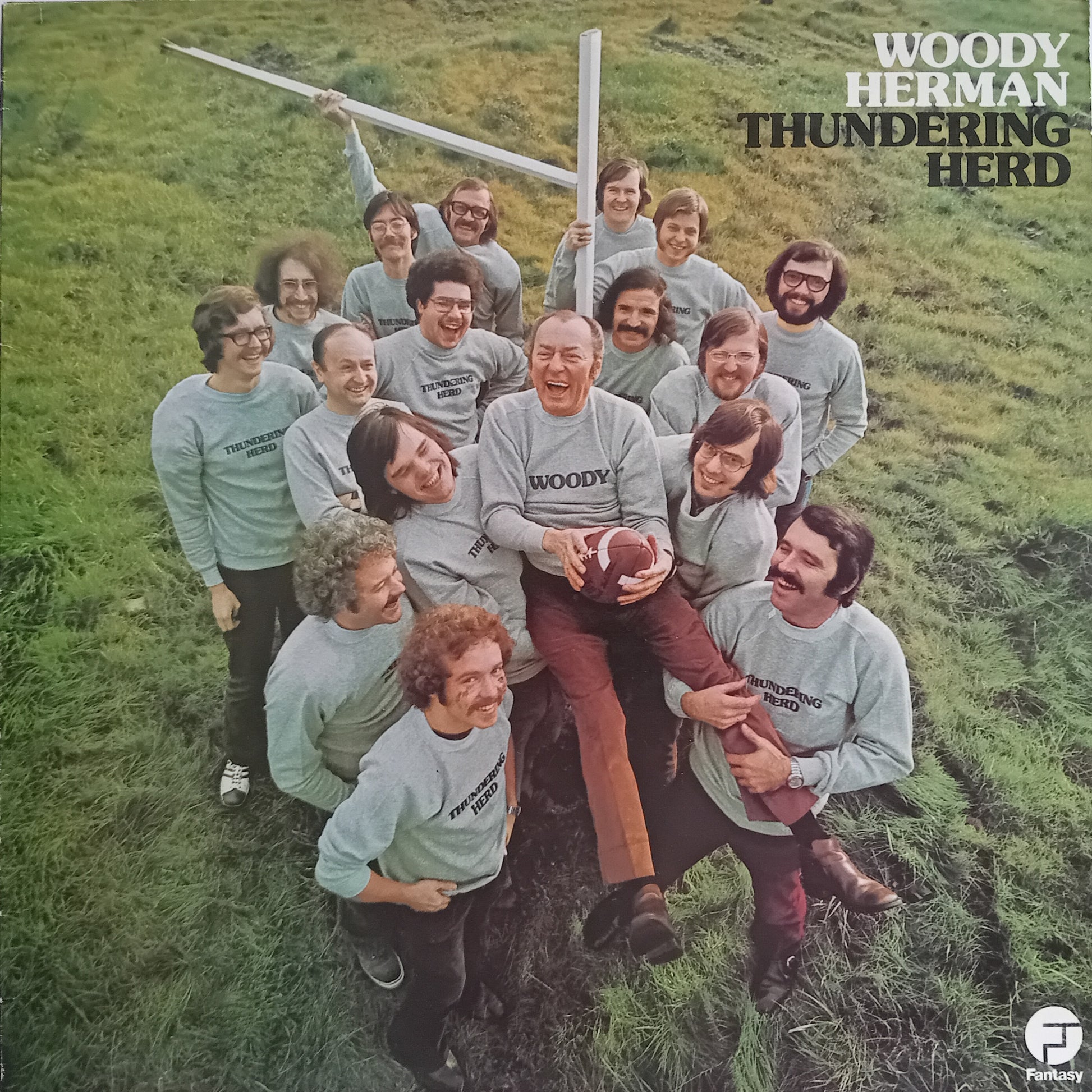 Album cover for 'Woody Herman Thundering Herd' featuring a group of people in a field.