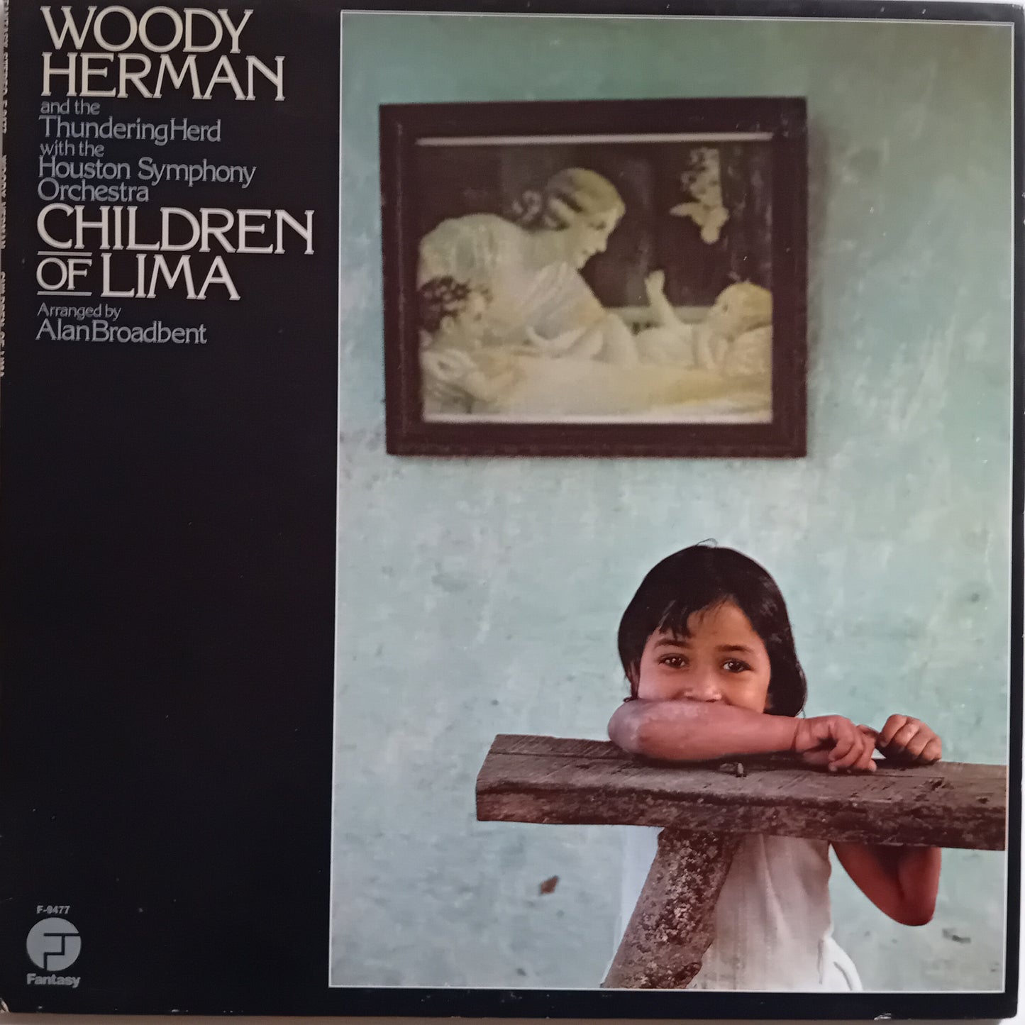 Album cover with a child holding a wooden block and a framed picture on a wall.