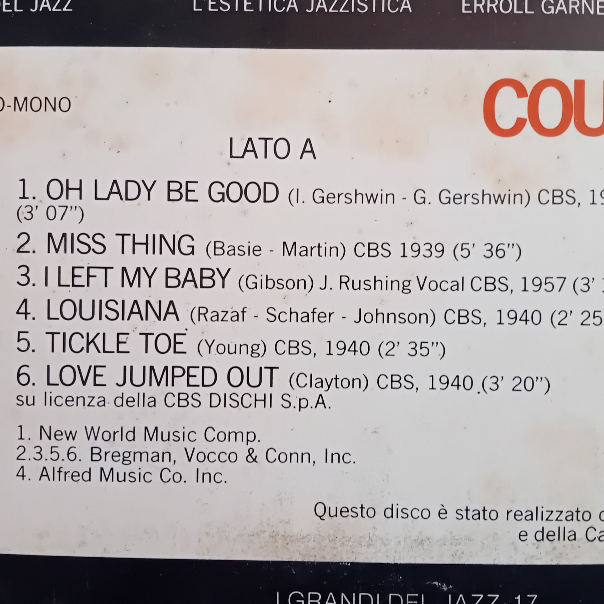 Album tracklist with song titles and artists on a beige background