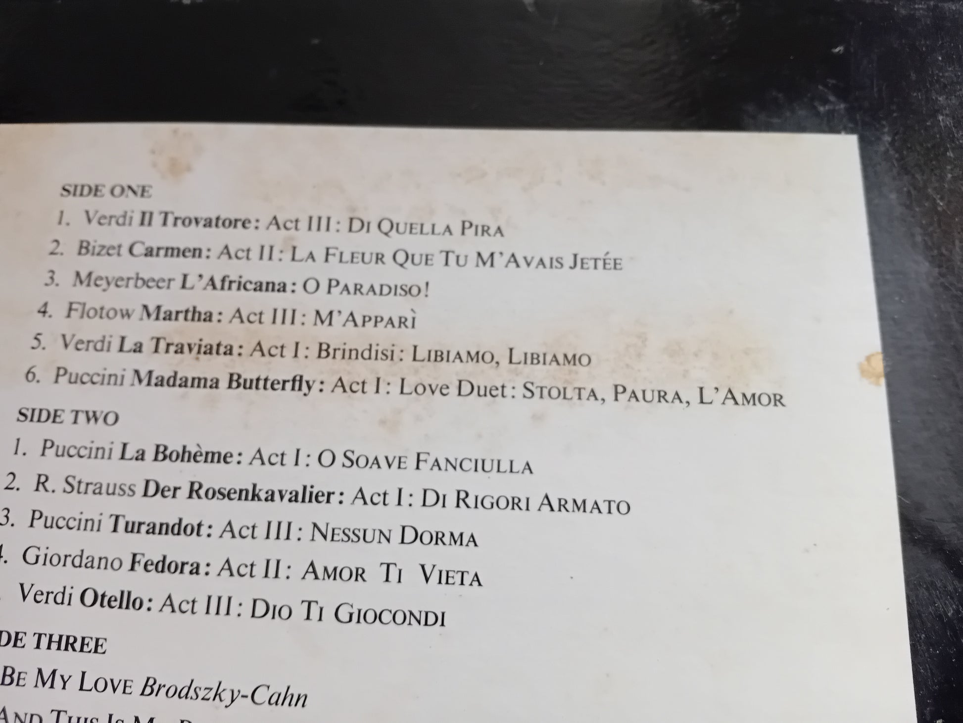 Music album tracklist on a black surface