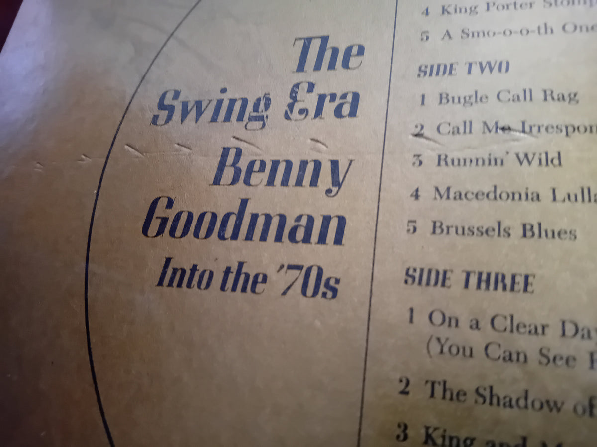 A close-up of printed cover art or booklet page for 'The Swing Era: Benny Goodman Into the 70s' with dark blue text on a tan paper background and a song list on the right side.