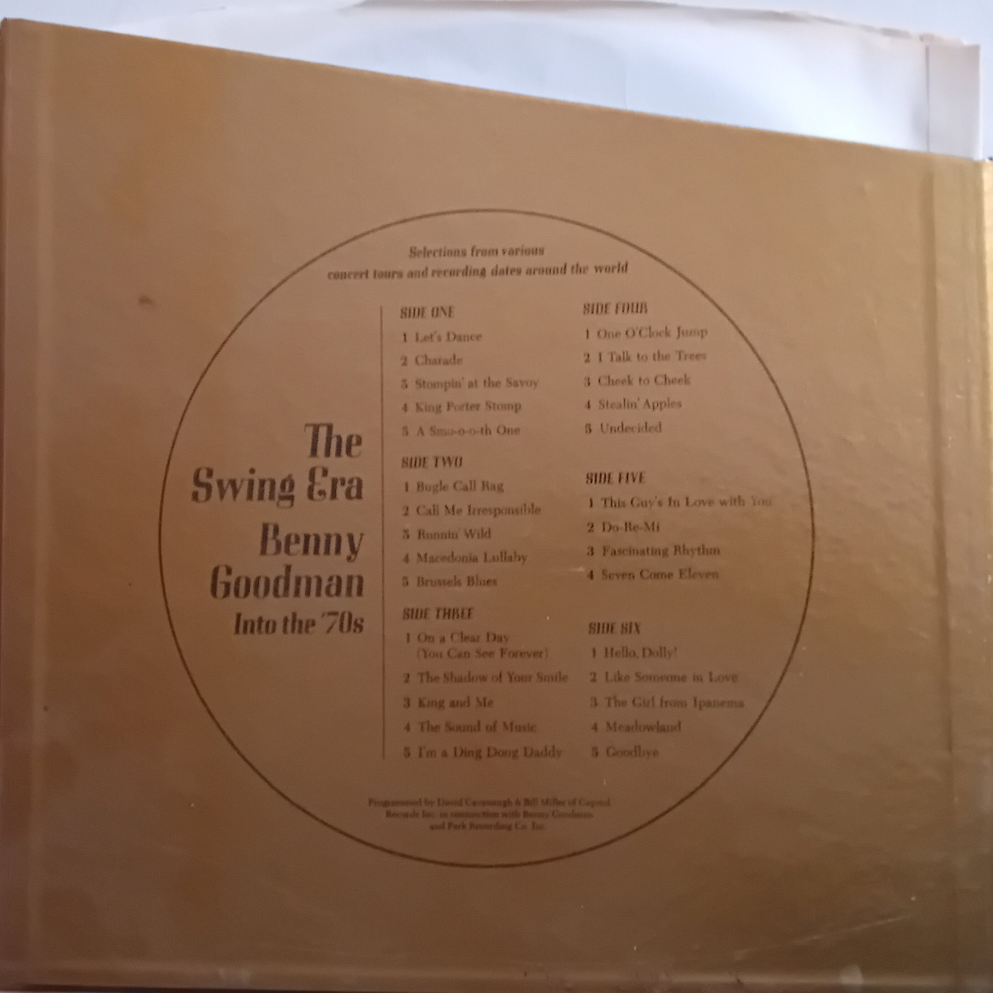The back cover of a vinyl record sleeve for 'The Swing Era Benny Goodman Into the 70s' by Benny Goodman, featuring a gold background with a circular tracklist and white text.