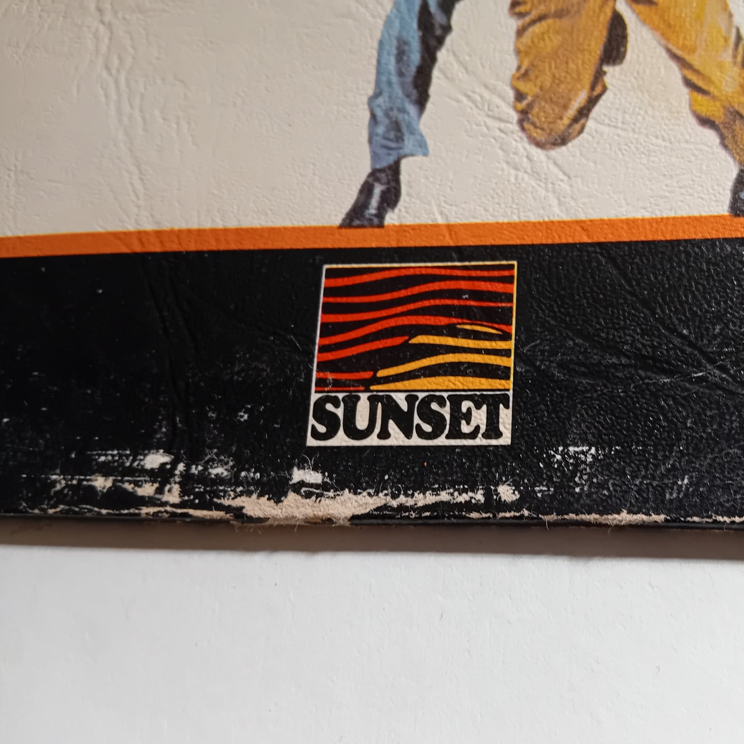 Close-up of 'Sunset' logo on a textured surface