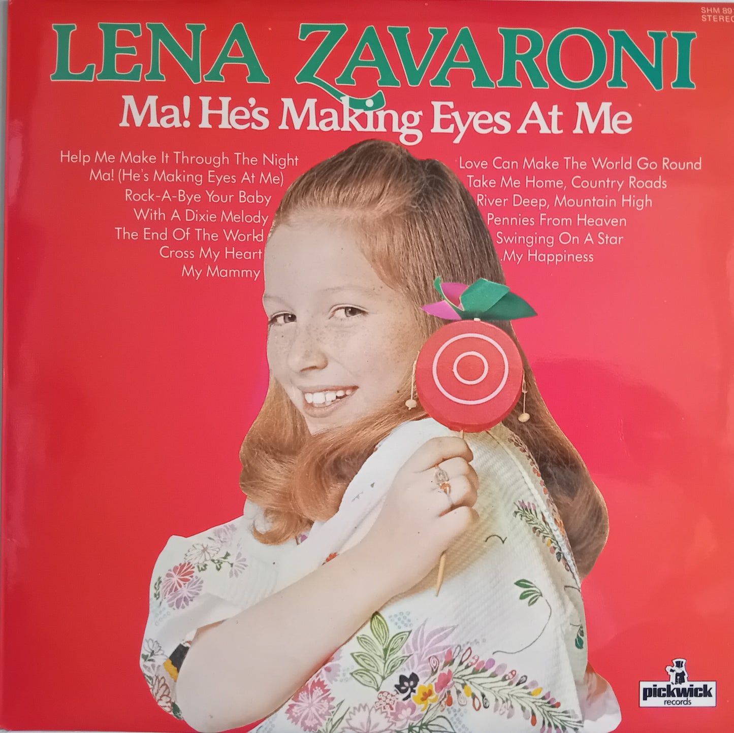 Lena Zavaroni 'Ma! He's Making Eyes At Me' vinyl record cover, featuring a young girl holding a red lollipop against a bright red background with green and white text.