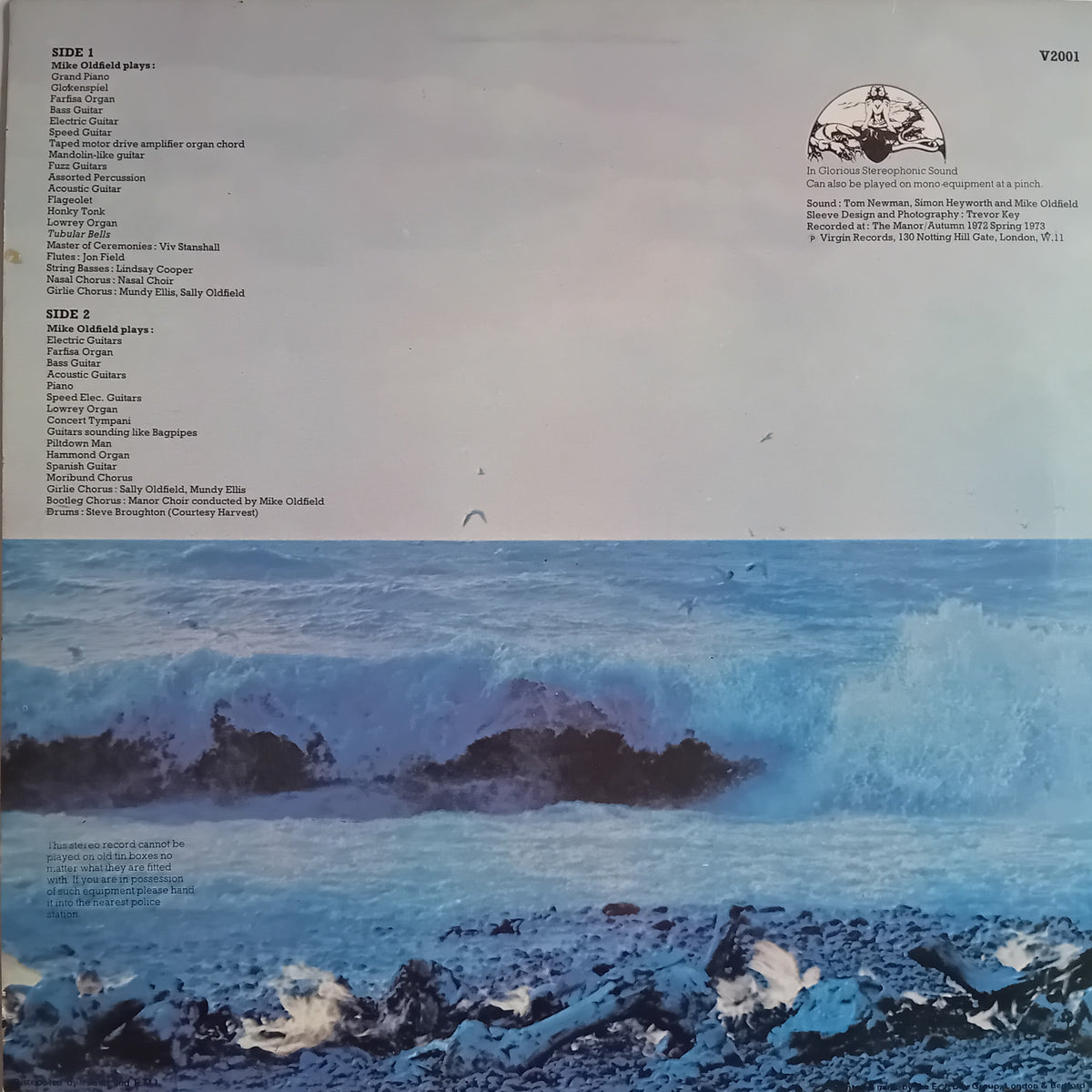 The back cover of a vinyl record sleeve for 'Tubular Bells' by Mike Oldfield, featuring a large blue-toned ocean wave illustration with surfers riding waves on the bottom half and track listings on the top half.