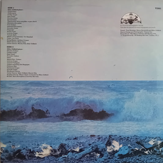 The back cover of a vinyl record sleeve for 'Tubular Bells' by Mike Oldfield, featuring a large blue-toned ocean wave illustration with surfers riding waves on the bottom half and track listings on the top half.