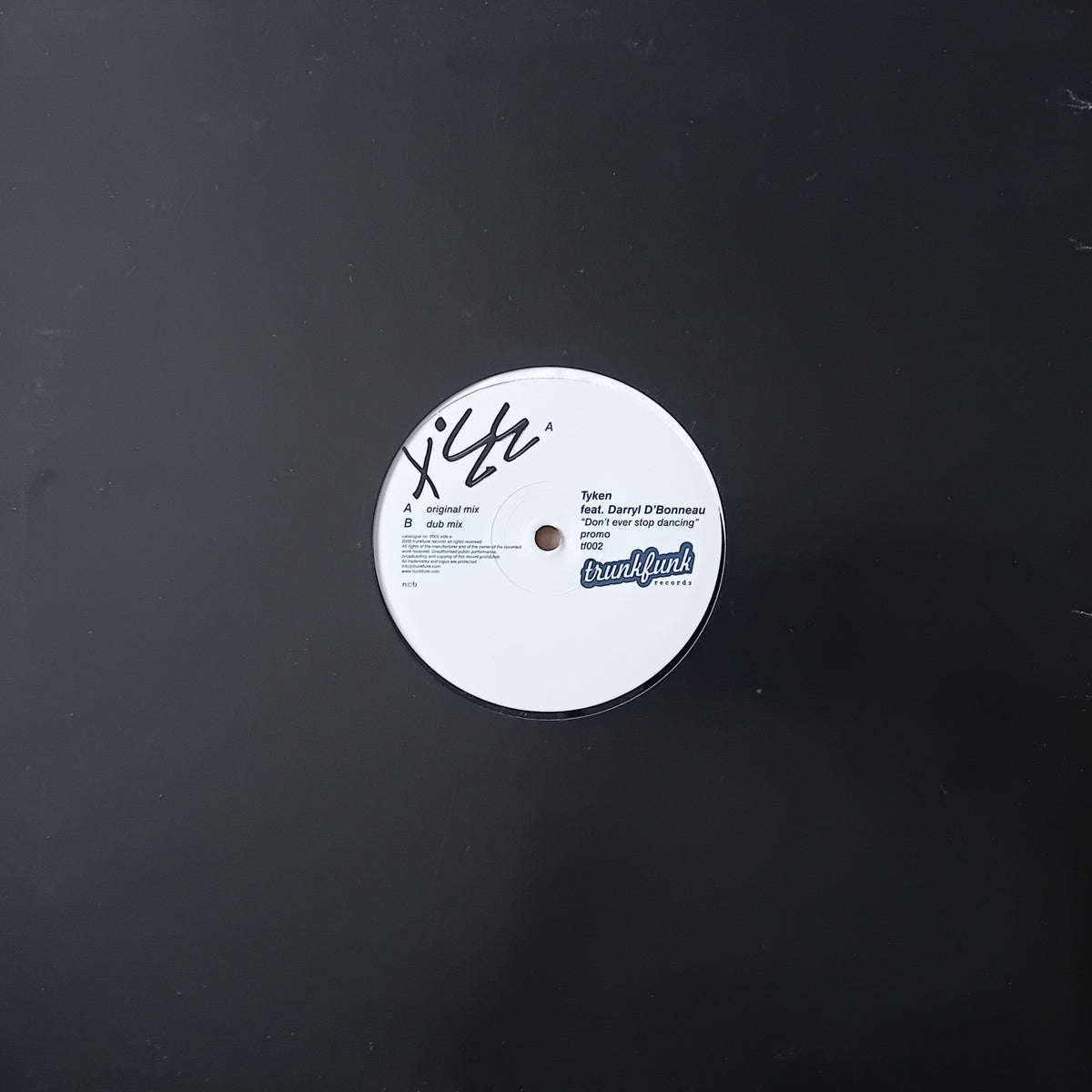 A vinyl record label from the artist Tyken, featuring the tracklist on a black background.