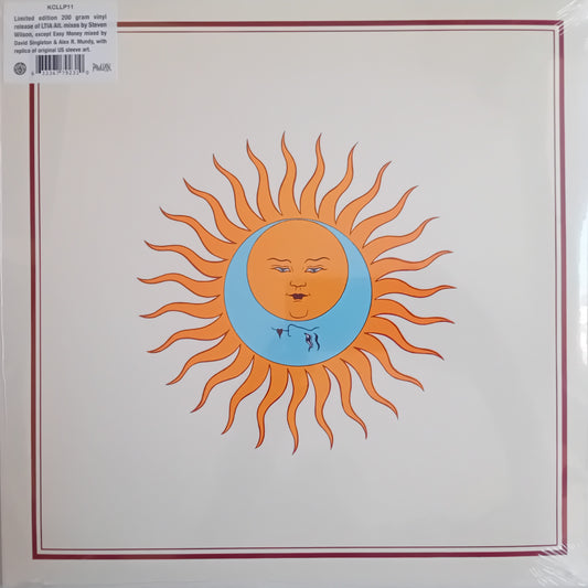 Vinyl record sleeve for King Crimson's 'Larks' Tongues In Aspic' LP, featuring a stylized orange sun with a crescent moon face on a cream background with a thin red border.