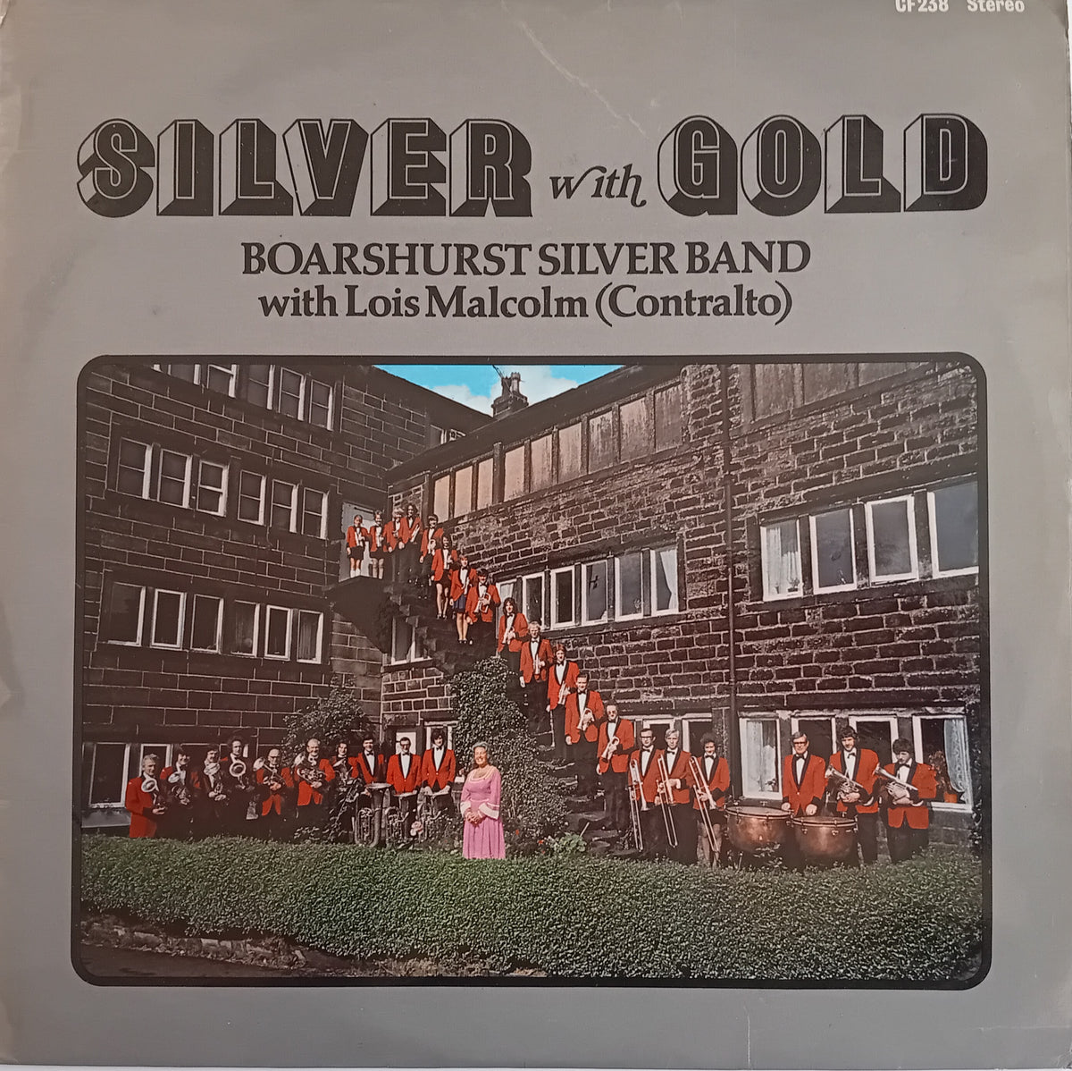 Vinyl record cover for 'Silver with Gold' by the Boarshurst Silver Band, featuring a colour photograph of the band in front of a brick building, with stylized black text at the top.