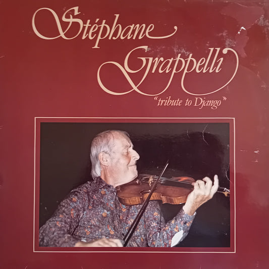 Vinyl album cover for 'Stéphane Grappelli - tribute to Django', featuring a portrait of the violinist on a dark red background with cream-coloured script text.
