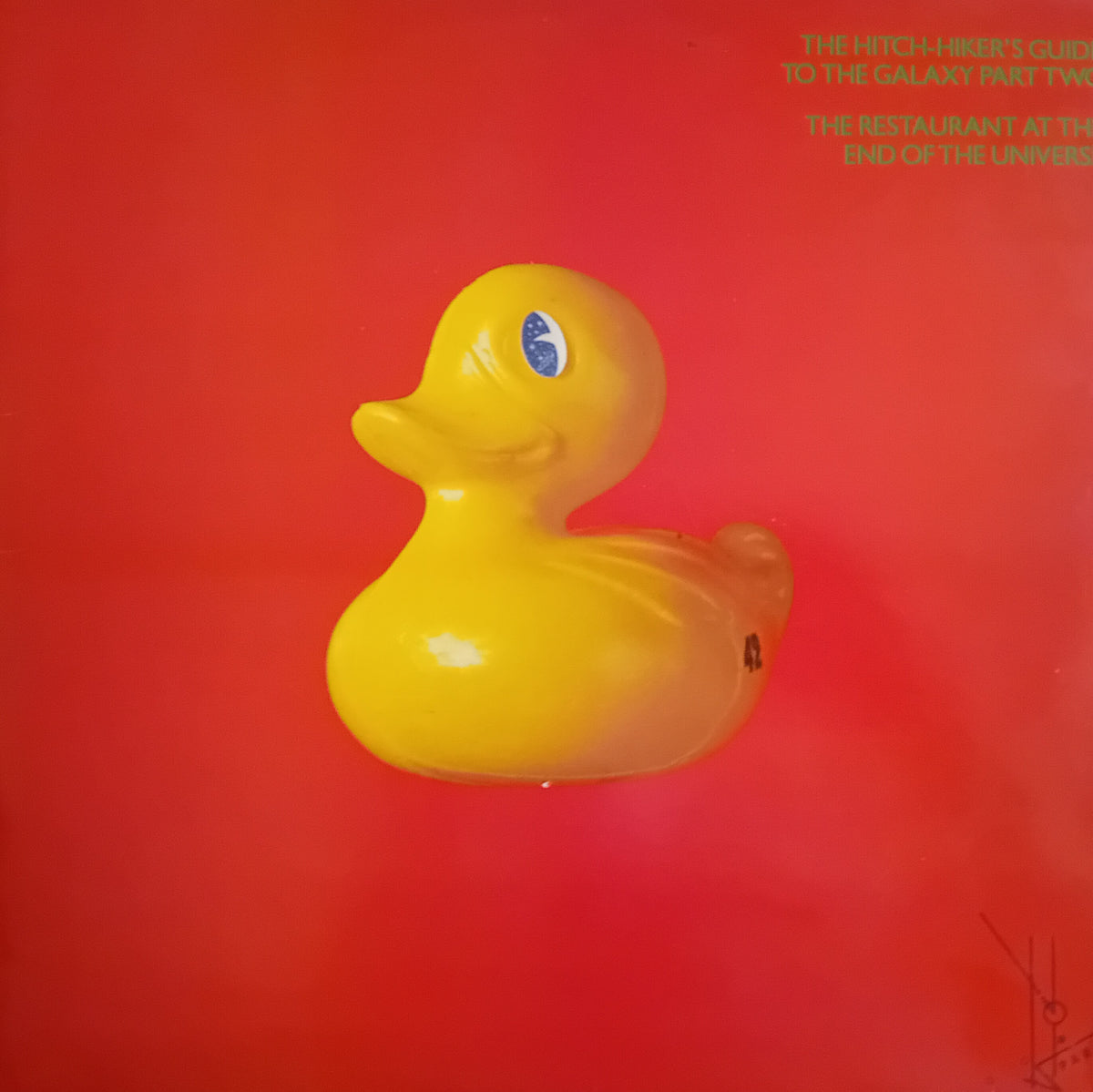 The iconic yellow rubber duck from Douglas Adams – The Hitch-Hiker's Guide To The Galaxy Part Two: The Restaurant At The End Of The Universe album cover, set against a vibrant red background with green text in the upper right.