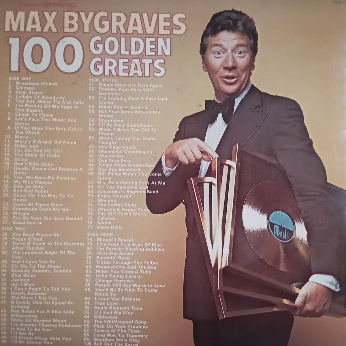 Vinyl record album cover for Max Bygraves' '100 Golden Greats', featuring a portrait of the artist in a tuxedo holding three gold records against a warm tan background with a tracklist on the left.