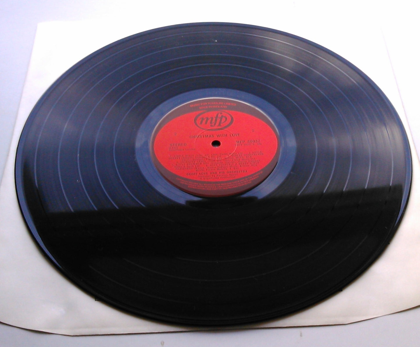 Vinyl record with a red label on a white background