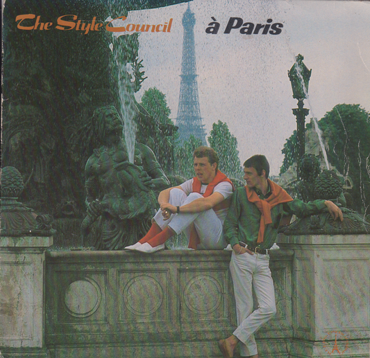 Single cover featuring two people sitting by a fountain with the Eiffel Tower in the background, titled 'The Style Council à Paris'.