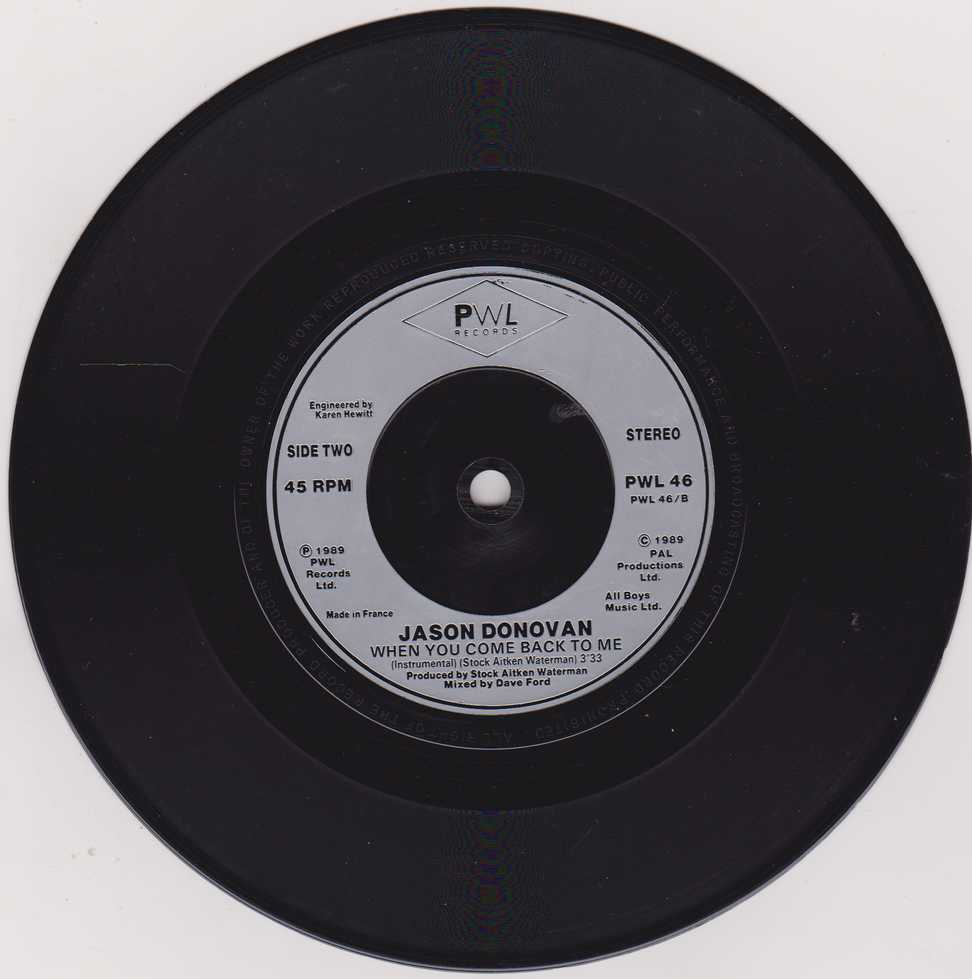 Vinyl record with PWL Records label on a white background