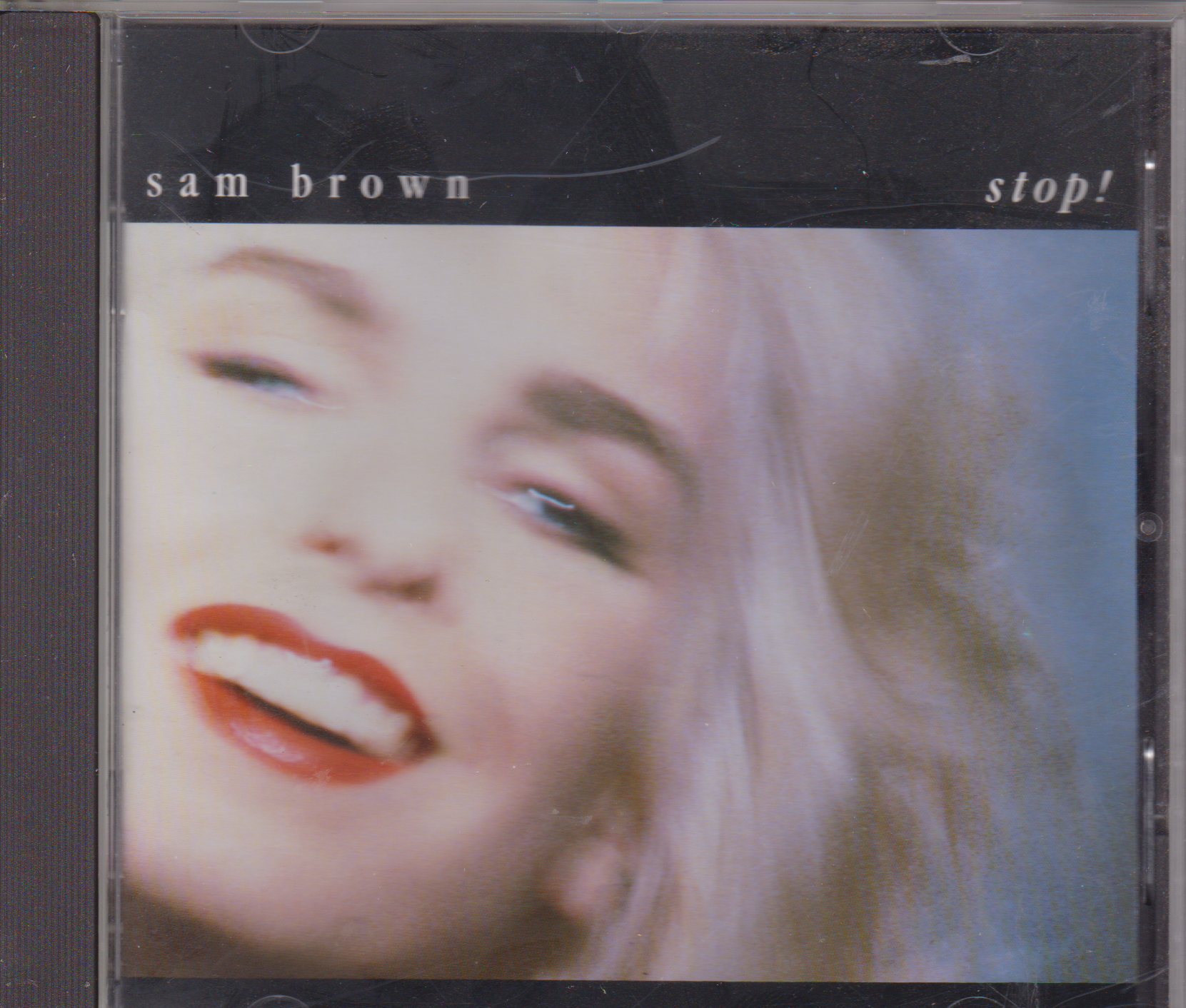 Album cover of 'stop!' by Sam Brown with a close-up of a person's face.