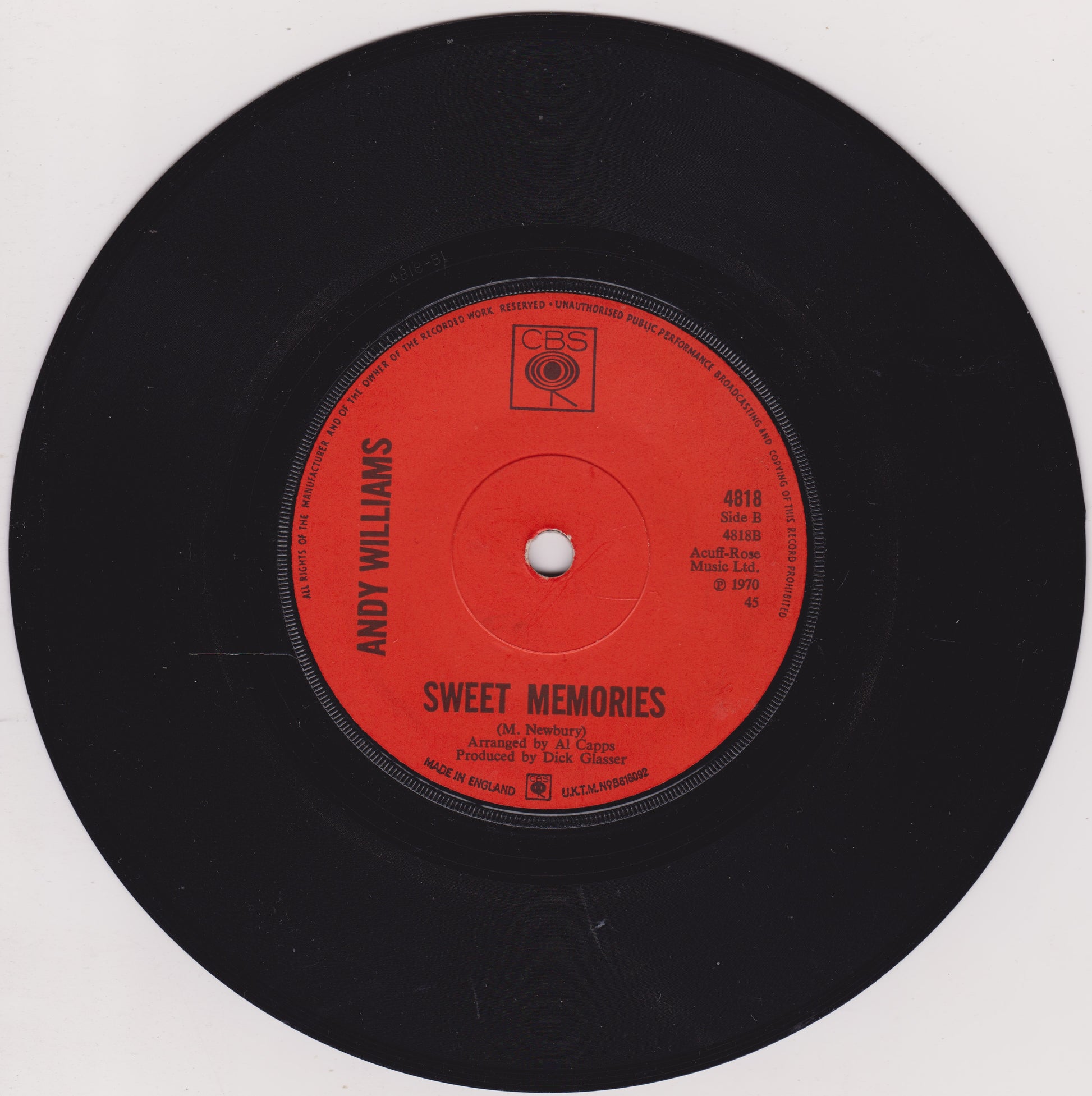 Record with red label featuring 'Andy Williams Sweet Memories' on a white background