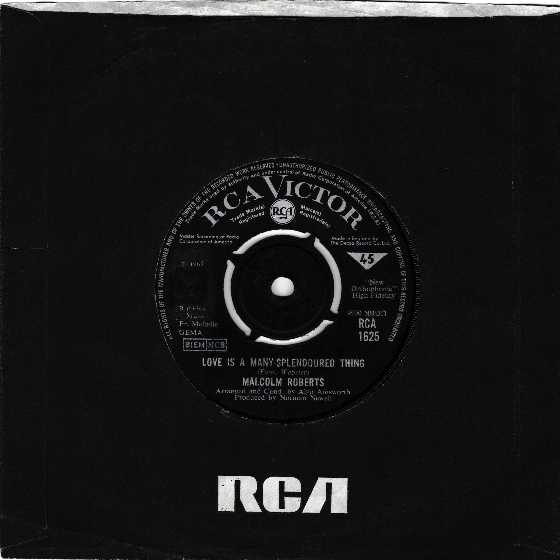 A black vinyl record partially pulled from its black paper sleeve, showing the RCA Victor label with the song title 'Love Is A Many Splendored Thing' by Malcolm Roberts and the RCA logo printed at the bottom of the sleeve.