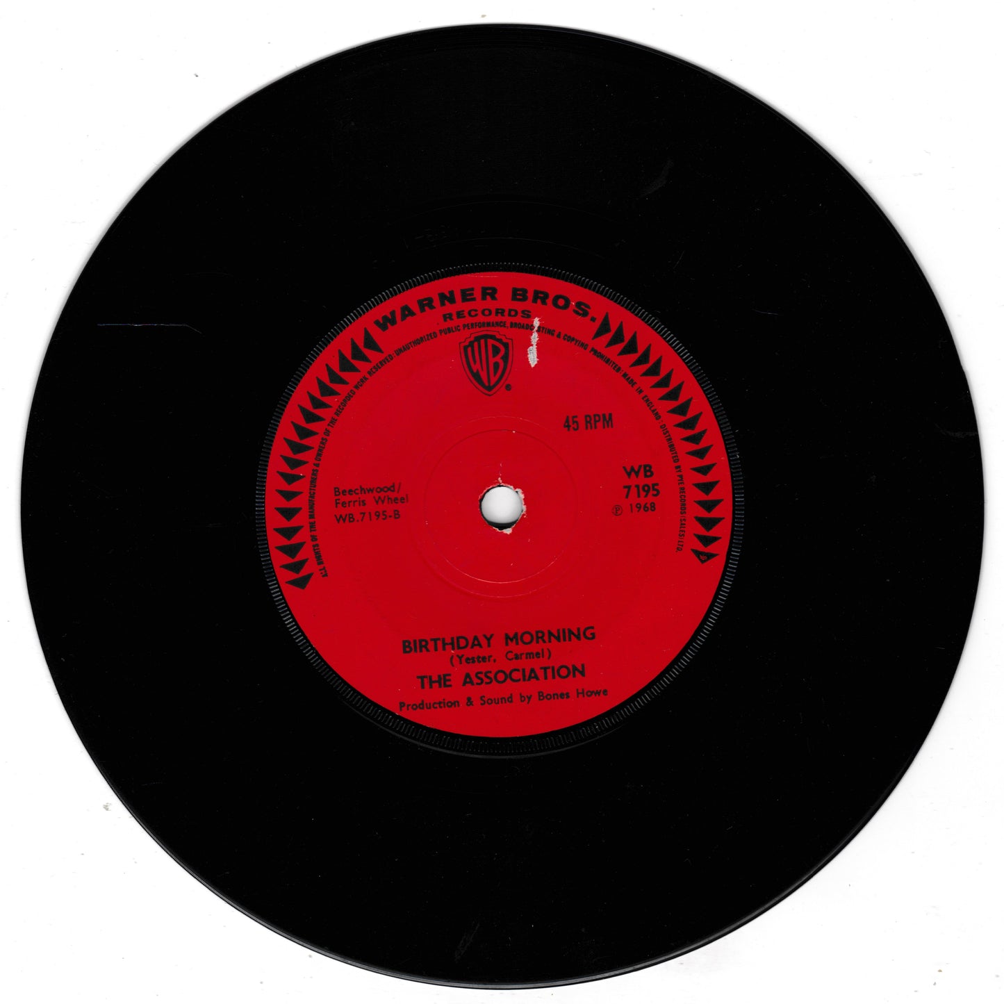 A black vinyl record with a bright red center label. The label reads 'WARNER BROS.