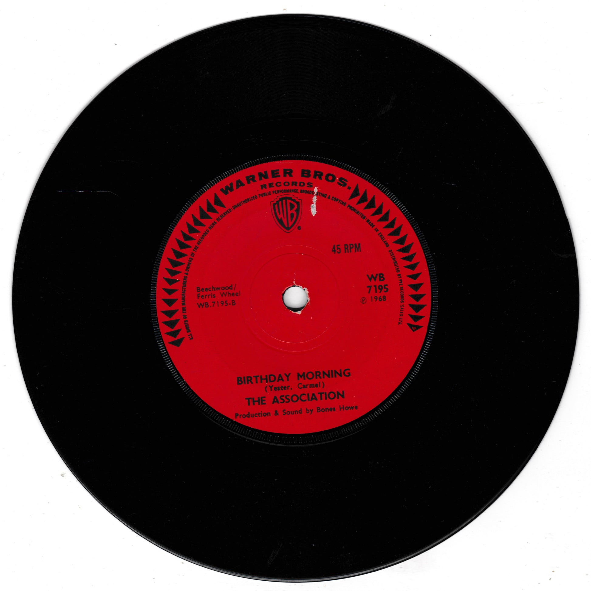 A black vinyl record with a bright red center label. The label reads 'WARNER BROS.