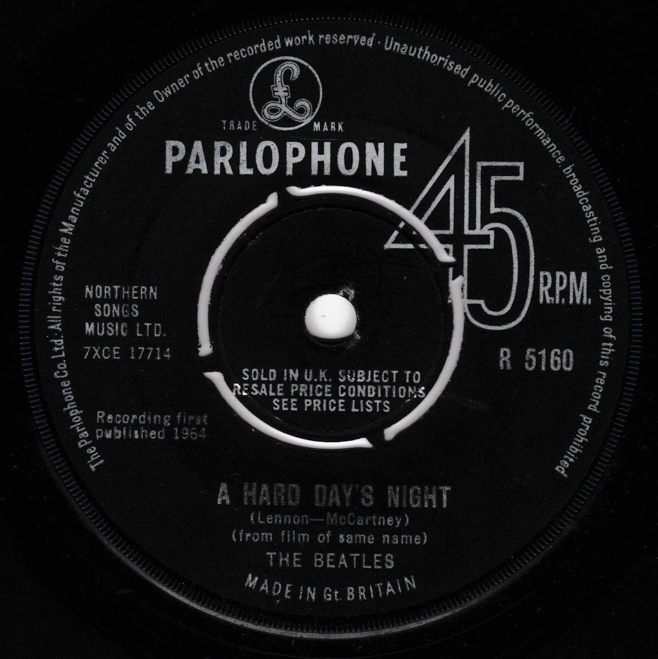 A close-up of a vintage Parlophone 45 RPM vinyl record label for The Beatles' 'A Hard Day's Night'. The black label features white text and a white center spindle area, with the Parlophone logo and catalog number R 5160 clearly visible.