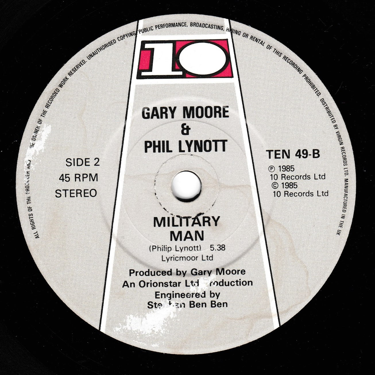 A close-up of a vinyl record label for 'Military Man' by Gary Moore & Phil Lynott, showing the 10 Records logo and track details on a black record surface.