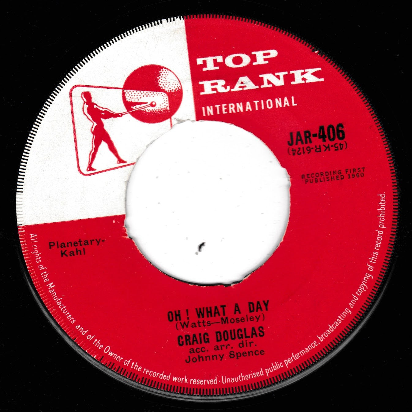 A vintage 7-inch vinyl record label for Top Rank International, featuring the song 'Oh! What a Day' by Craig Douglas with Johnny Spence. The label is red and white with black text and a central white spindle hole, photographed against a black background.