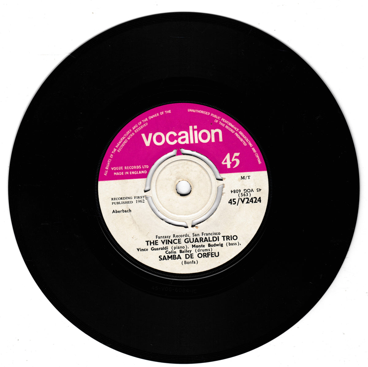 A black vinyl record with a pink and white centre label. The label reads 'vocalion' and shows the artist name 'The Vince Guaraldi Trio' and track title 'Samba de Orfeu'.
