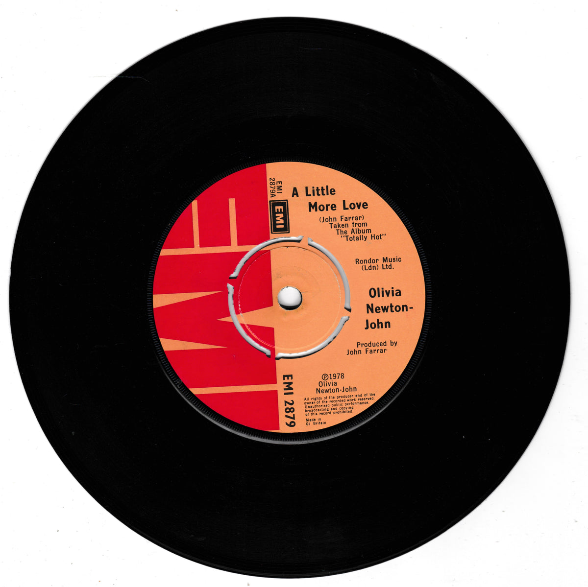 A black vinyl record with a red and orange centre label reading 'A Little More Love' by Olivia Newton-John, photographed on a plain white background.