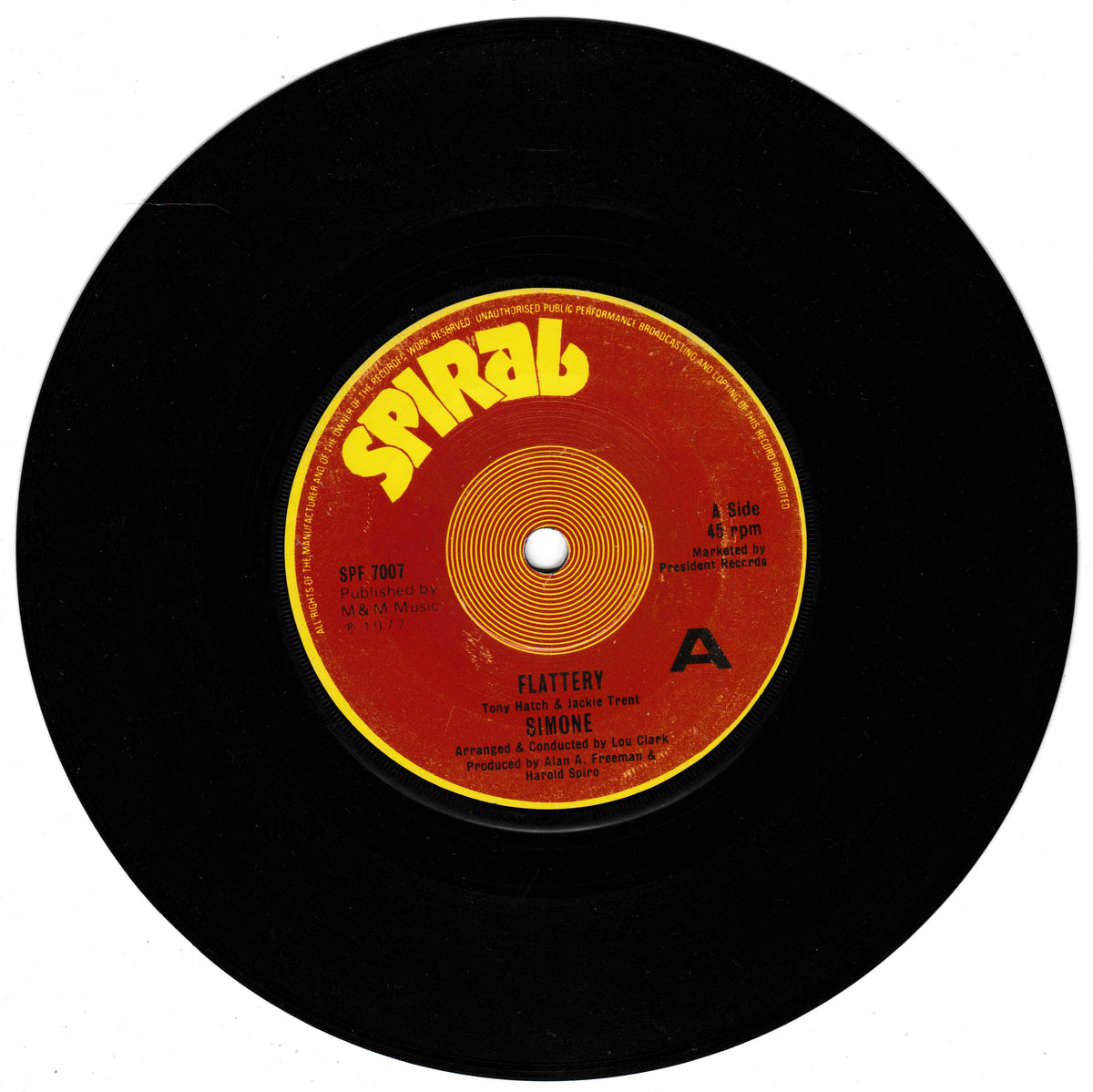A black vinyl record with a red and yellow Spiral Records label, featuring the song 'Flattery' by Simon, shown against a plain white background.