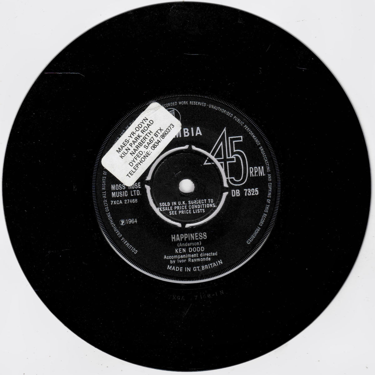 A black 45 RPM vinyl record label for Ken Dodd's 'Happiness' on Columbia Records, with a white sticker covering part of the centre label.