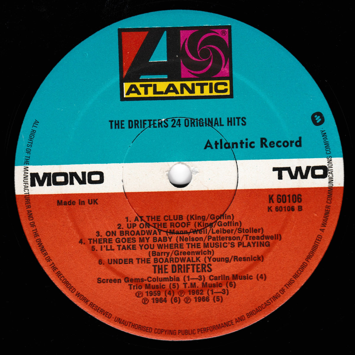 A close-up of a vinyl record label for The Drifters' '24 Original Hits' on Atlantic Records. The label is split horizontally into a turquoise-blue upper half and an orange-red lower half, with a white band across the centre.