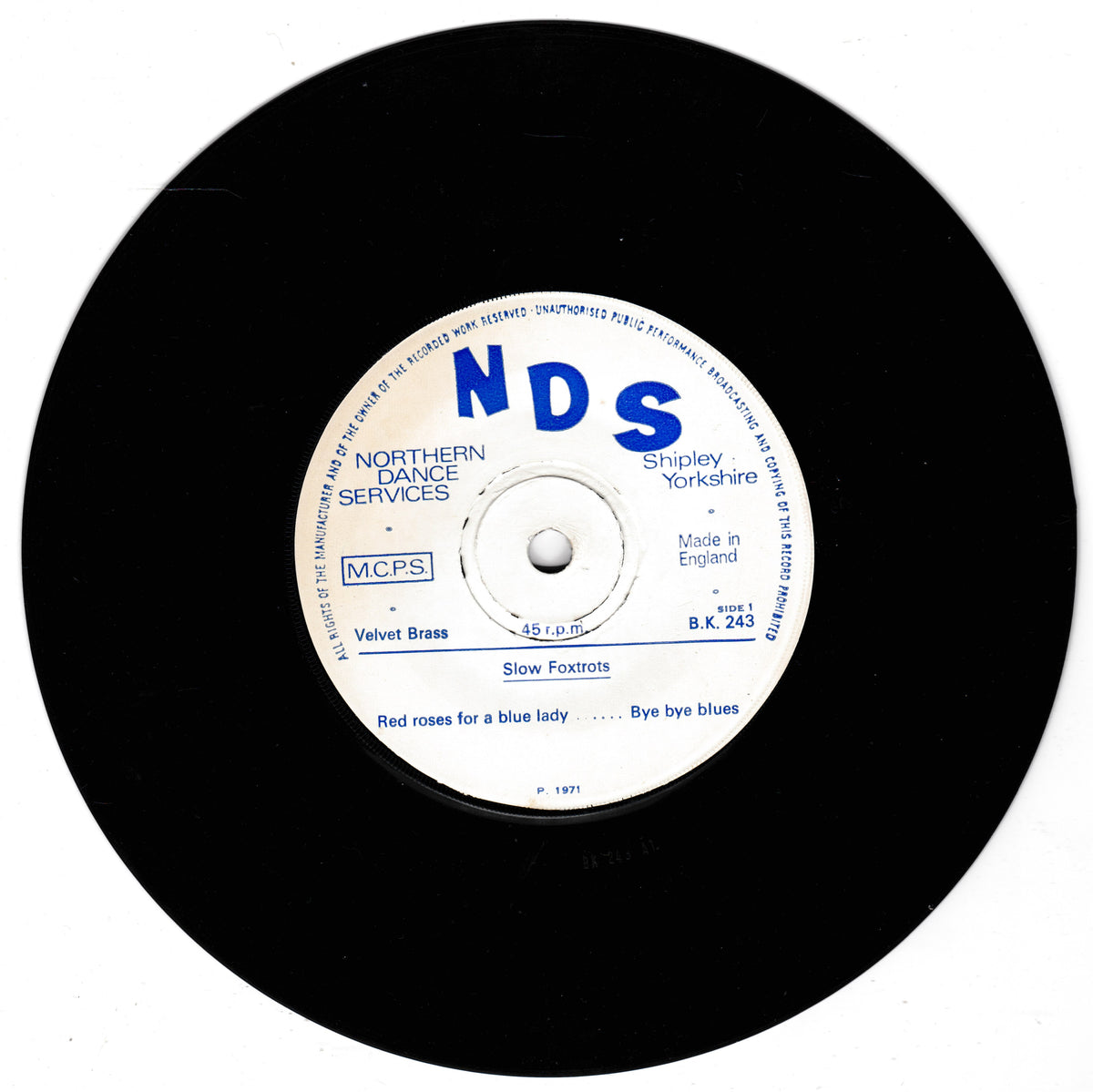 A black vinyl record with a white centre label featuring blue text. The label shows the prominent 'NDS' logo and details for 'Slow Foxtrots' by 'Velvet Brass', manufactured in England by Northern Dance Services in Shipley, Yorkshire.