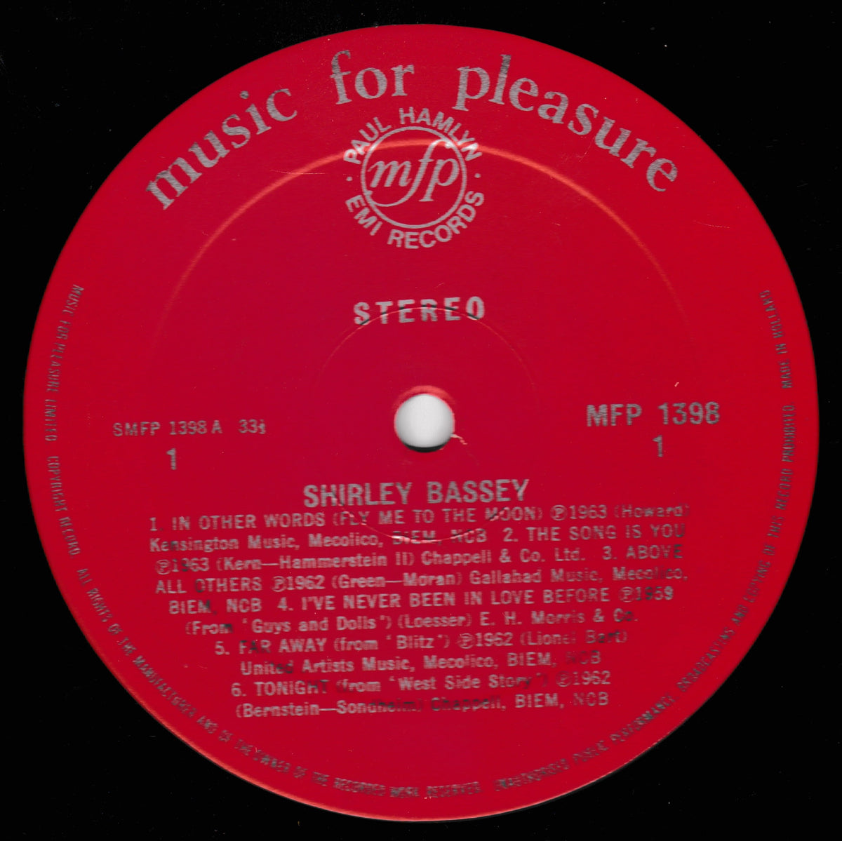 A red vinyl record label for Shirley Bassey's 'The Fabulous' on MFP 1398, featuring white text and the Paul Hamlyn Est. Records logo, photographed against a black record sleeve.