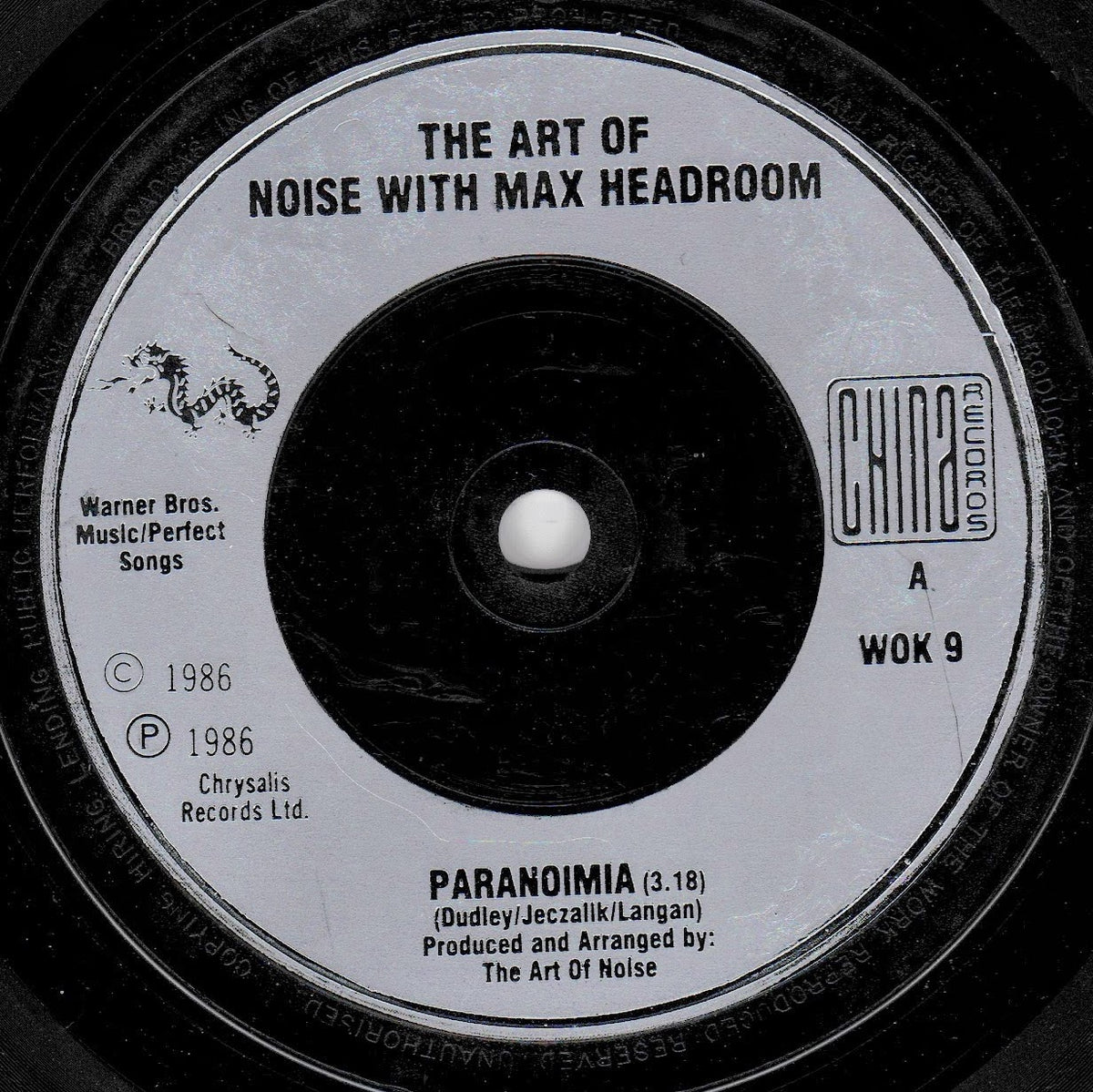 A close-up of a vinyl record label reading 'THE ART OF NOISE WITH MAX HEADROOM' and 'PARANOIMIA,' with Chrysalis Records branding and black-and-white contrast.