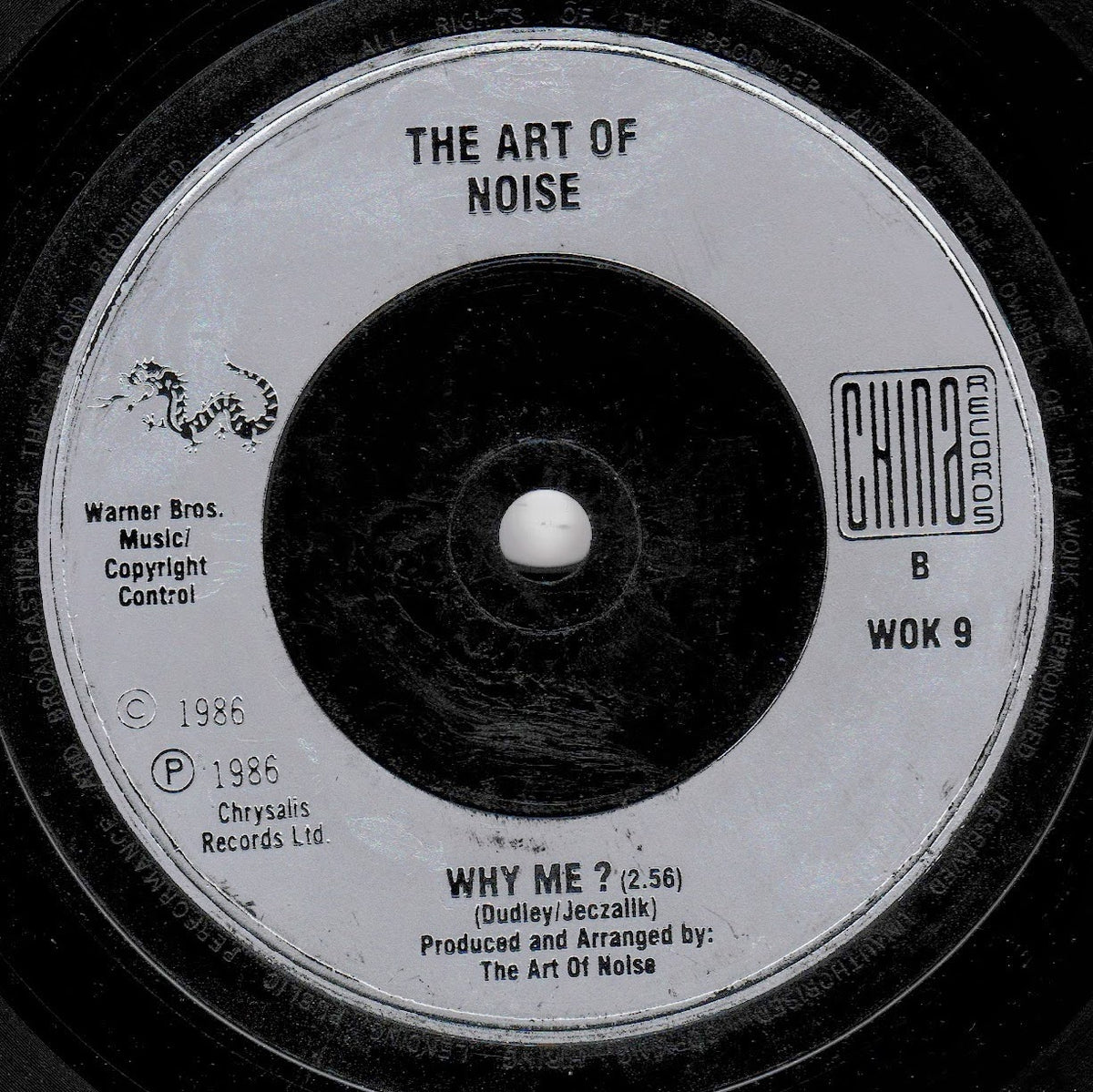 A close-up of a vintage vinyl record label for 'The Art of Noise' and the song 'Why Me?'. The label is white with black text and a black centre, showing Warner Bros.