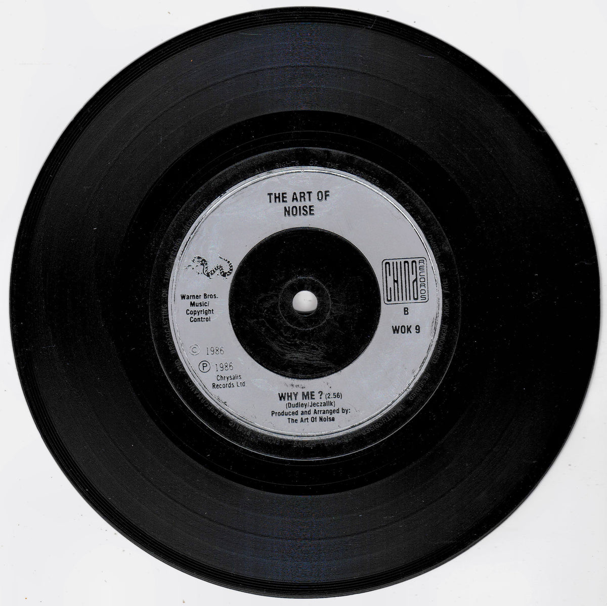 A black vinyl record with a white centre label reading 'THE ART OF NOISE' and 'WHY ME?', photographed on a plain white background.
