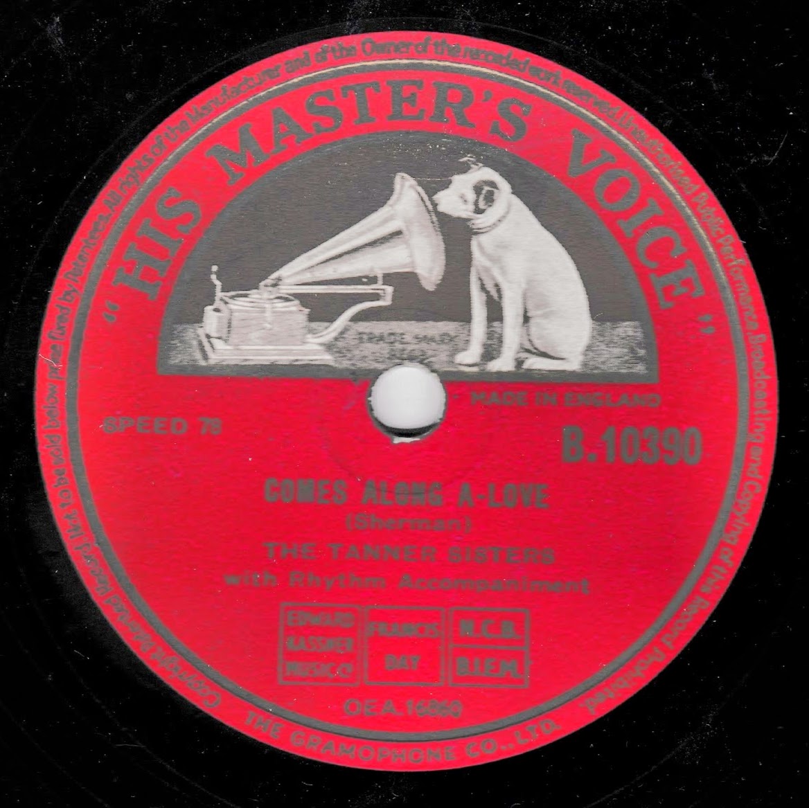 A vintage red vinyl record label for 'Comes Along A-Love' by The Tanner Sisters, featuring a black-and-white illustration of a dog and a gramophone. The label includes 'His Master's Voice' branding.