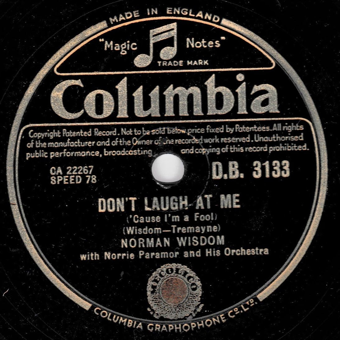 A vintage Columbia record label for 'Don't Laugh At Me' by Norman Wisdom, featuring black shellac with cream-coloured text and border details.