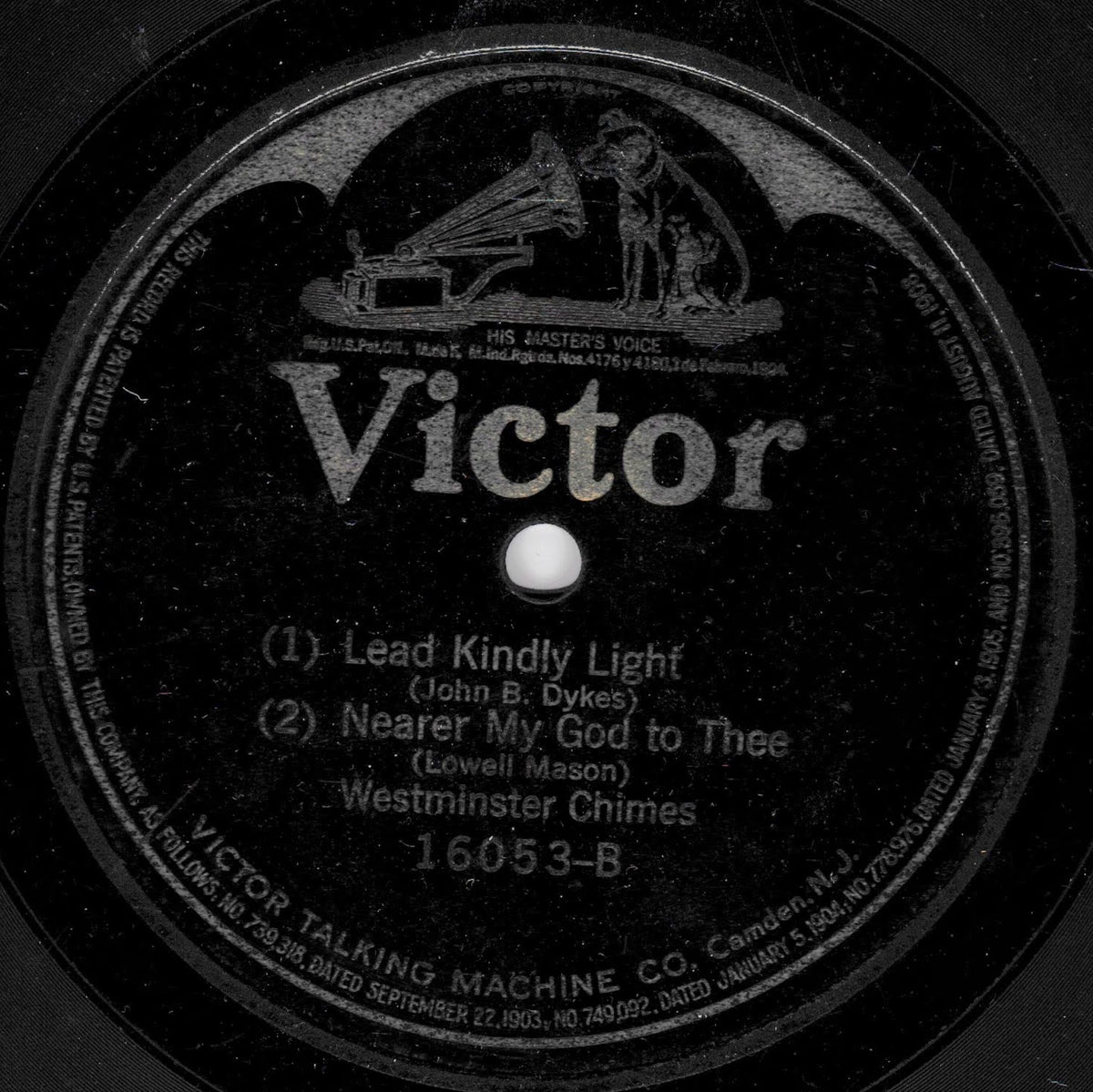 A close-up of a vintage Victor record label with the text 'Victor' in large white letters and song titles for 'Lead Kindly Light' and 'Nearer My God to Thee' by Westminster Chimes.