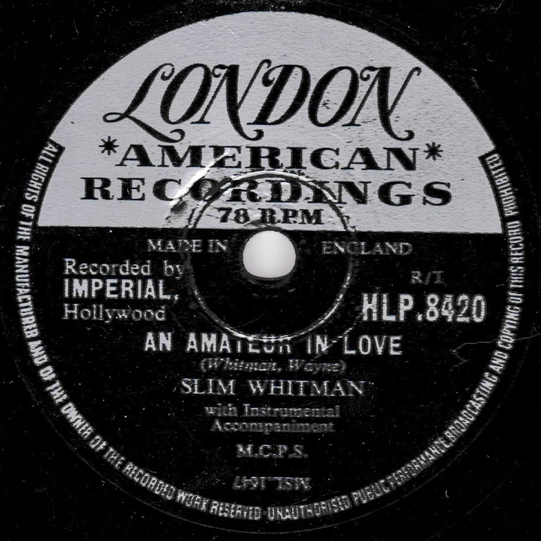 A close-up of a vintage 78 RPM record label for Slim Whitman's 'An Amateur in Love' from London American Recordings, Imperial Records, with black, white, and gray tones.