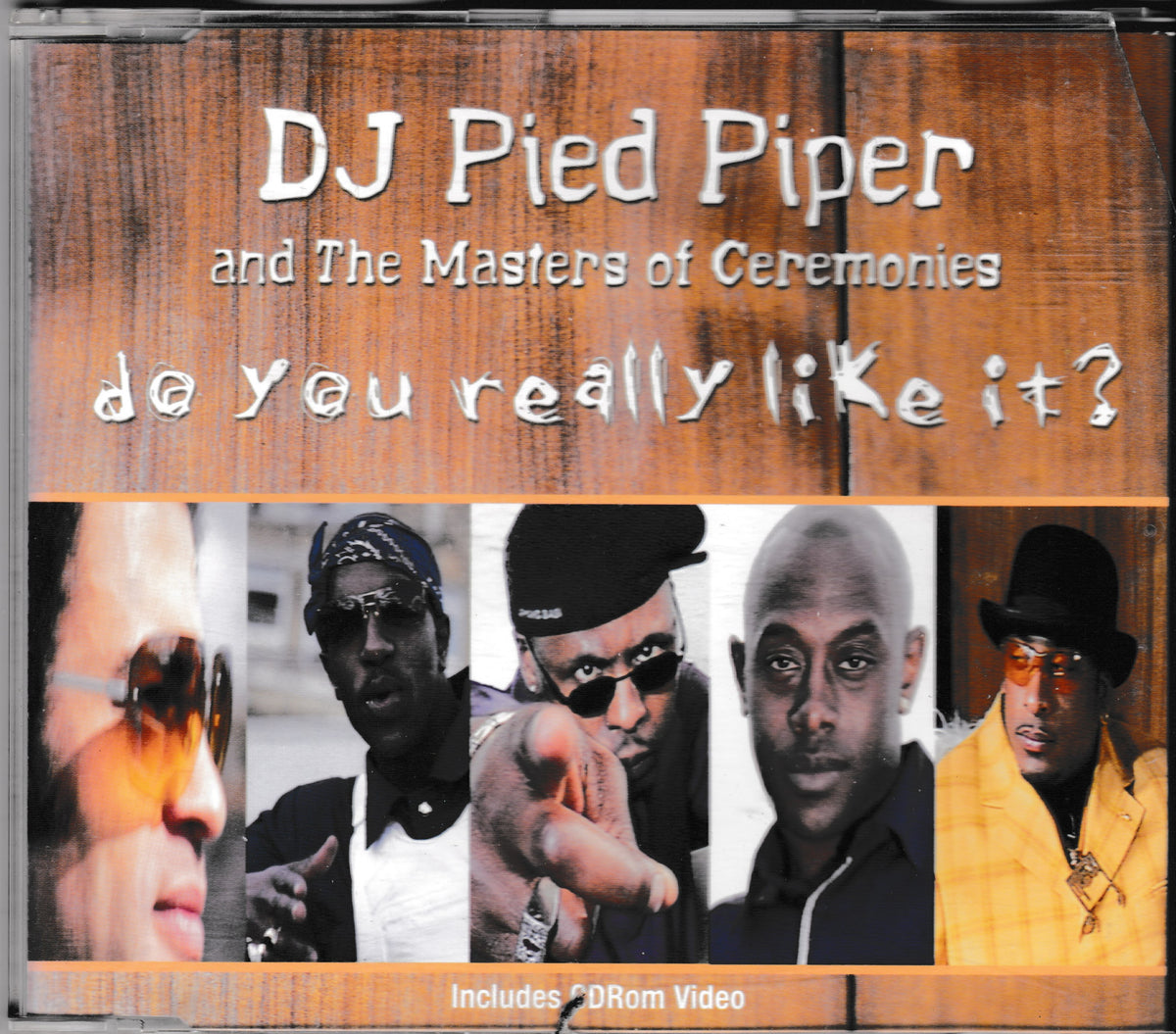 CD cover for 'do you really like it?' by DJ Pied Piper and The Masters of Ceremonies, featuring a wood-grain background with stylized white text and a horizontal strip of five portrait photos of hip-hop artists at the bottom.
