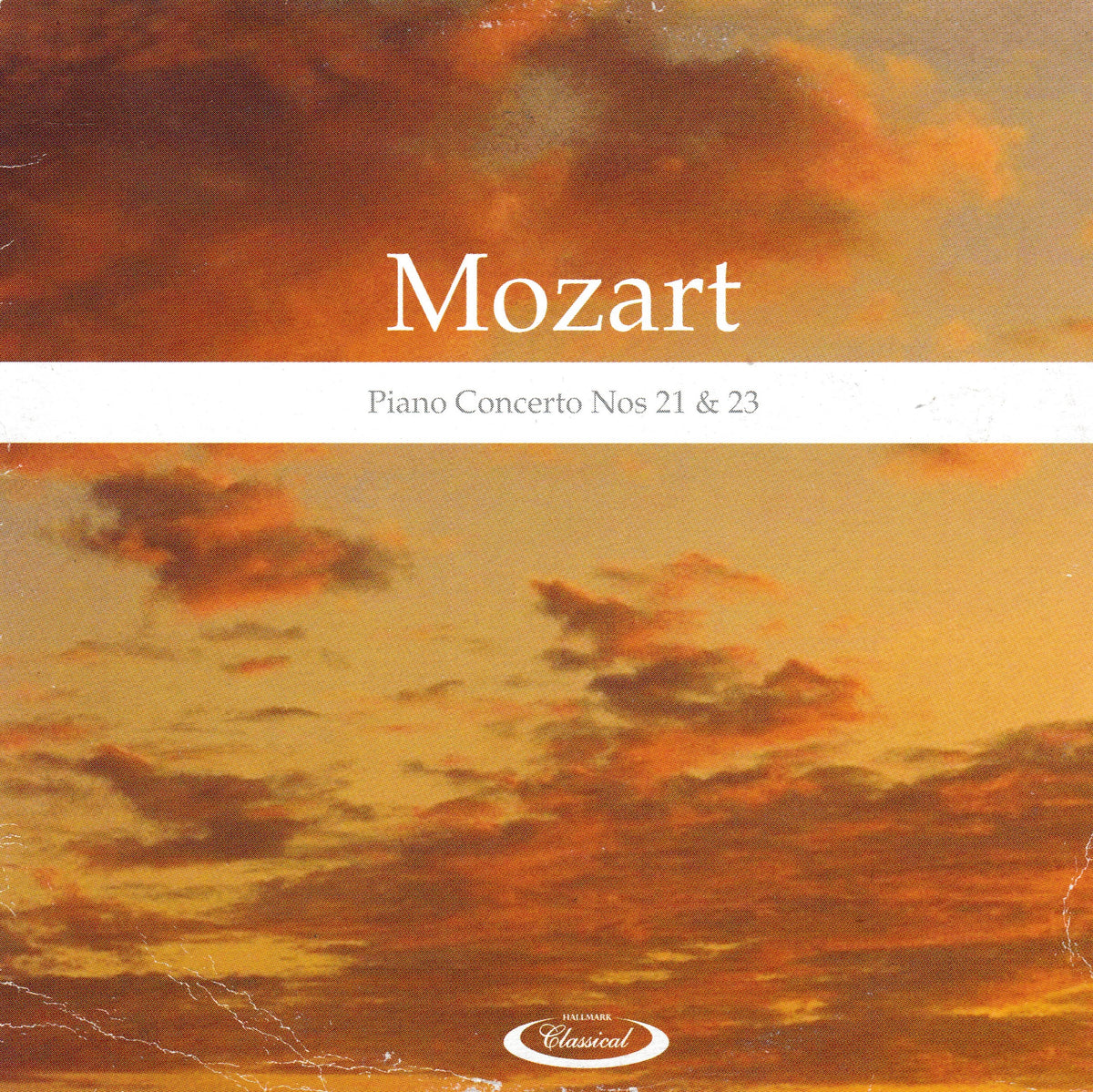 Album cover for Mozart's Piano Concerto Nos 21 & 23, featuring a warm-toned sunset sky with orange, yellow, and brown clouds. The word 'Mozart' is printed in large white serif text across the centre, with 'Piano Concerto Nos 21 & 23' below it.