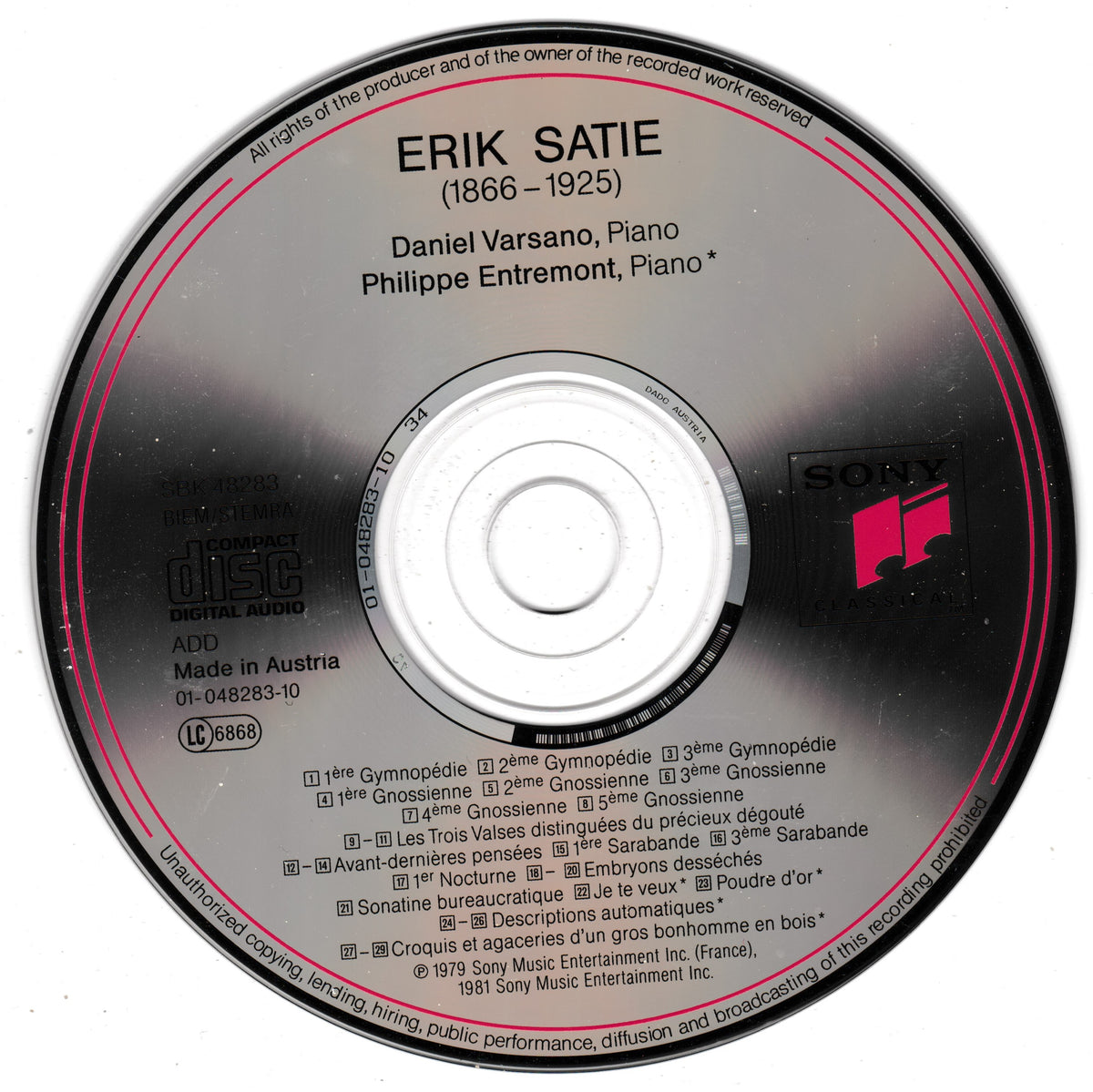 A close-up of a compact disc with Erik Satie's 'Daniel Versano, Piano' on a Sony CD release. The disc features a reflective surface with pink circular accents, white text, and the pink Sony logo in the lower right.